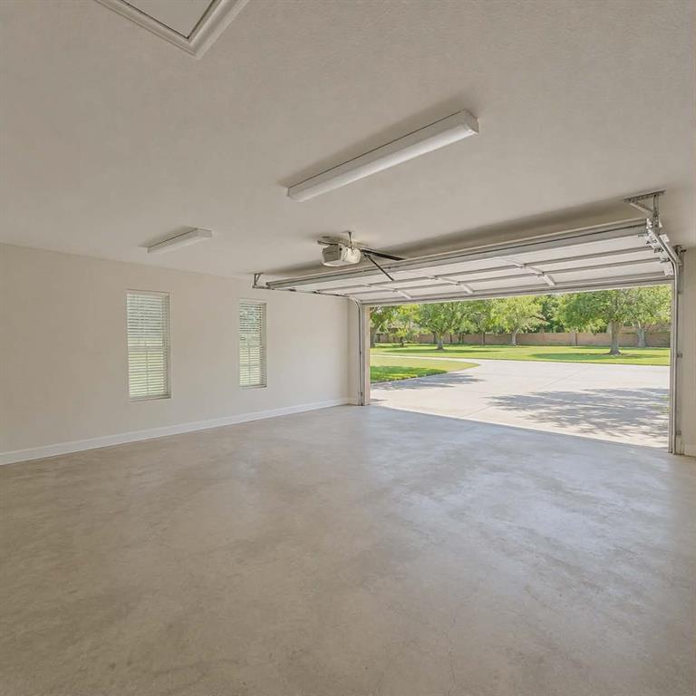 14752 Ranch Road Forney, TX 75126 - Photo 34 of 40 Spacious two vehicle garage featuring a concrete floor, two windows with blinds, ceiling-mounted fluorescent lighting, an automatic garage door opener, and a raised garage door