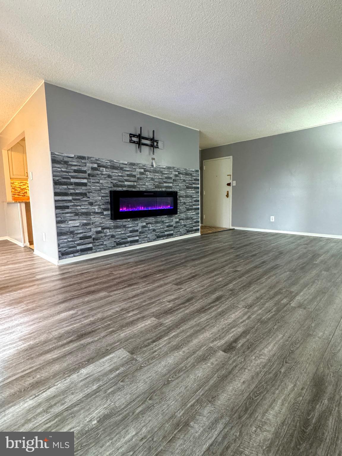 2300 Pimmit Drive, Unit 719 Falls Church, VA 22043 - Photo 4 of 15 a view of an empty room with wooden floor and a fireplace