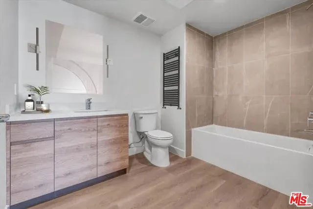 a bathroom with a granite countertop sink a toilet and bathtub