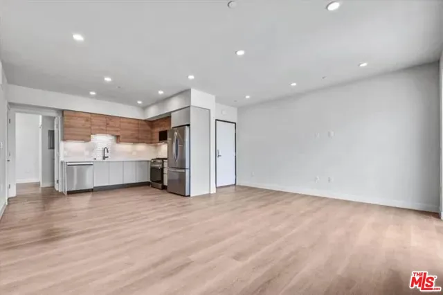 a view of an empty room with a sink and cabinets