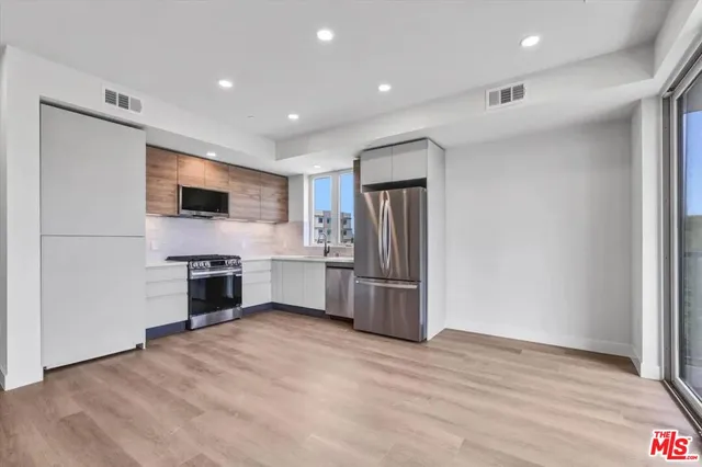 a kitchen with a refrigerator and a stove top oven