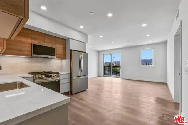 a kitchen with a refrigerator and a stove top oven