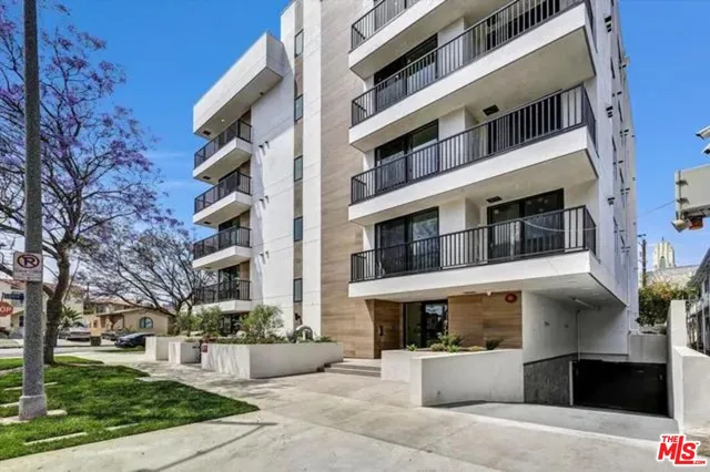 a front view of a multi story building with yard