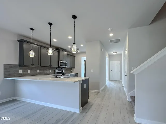 a view of a kitchen with a sink and wooden floor