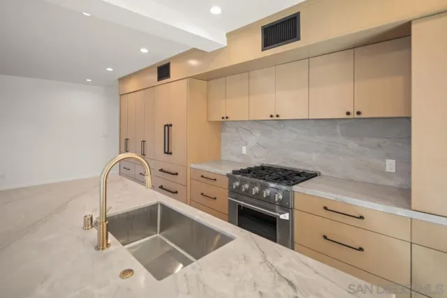 a kitchen with granite countertop a stove sink and cabinets