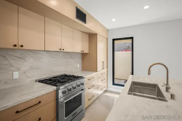 a kitchen with granite countertop a sink stainless steel appliances and cabinets