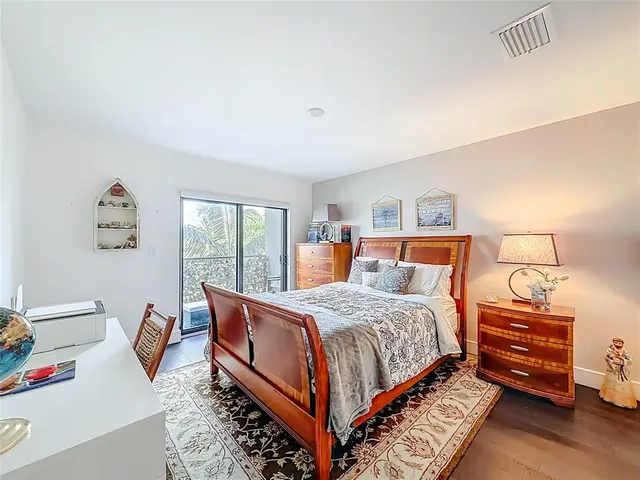 a bedroom with bed and wooden floor