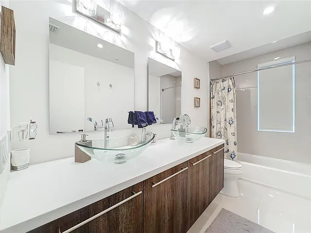 a bathroom with a double vanity sink toilet and shower