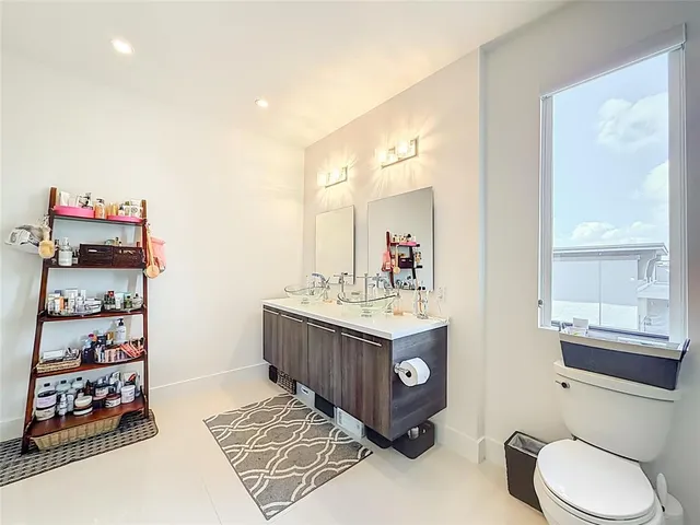 a bathroom with a sink a toilet and a mirror