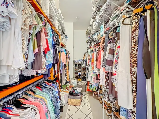 a view of walk in closet with clothes