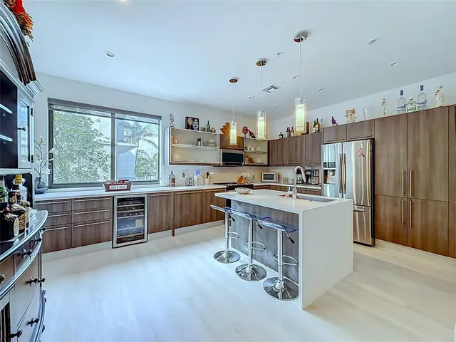 a kitchen with kitchen island a sink stove and refrigerator