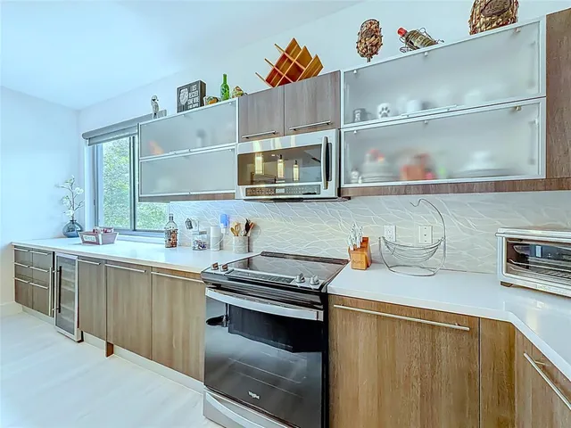 a kitchen with stainless steel appliances a sink dishwasher stove and cabinets