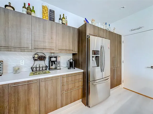 a kitchen with stainless steel appliances a refrigerator a sink a stove and a refrigerator