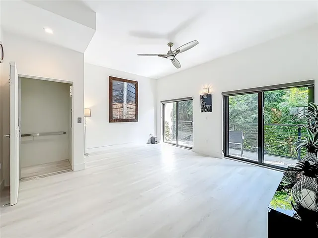 a view of an empty room with a window and a livingroom