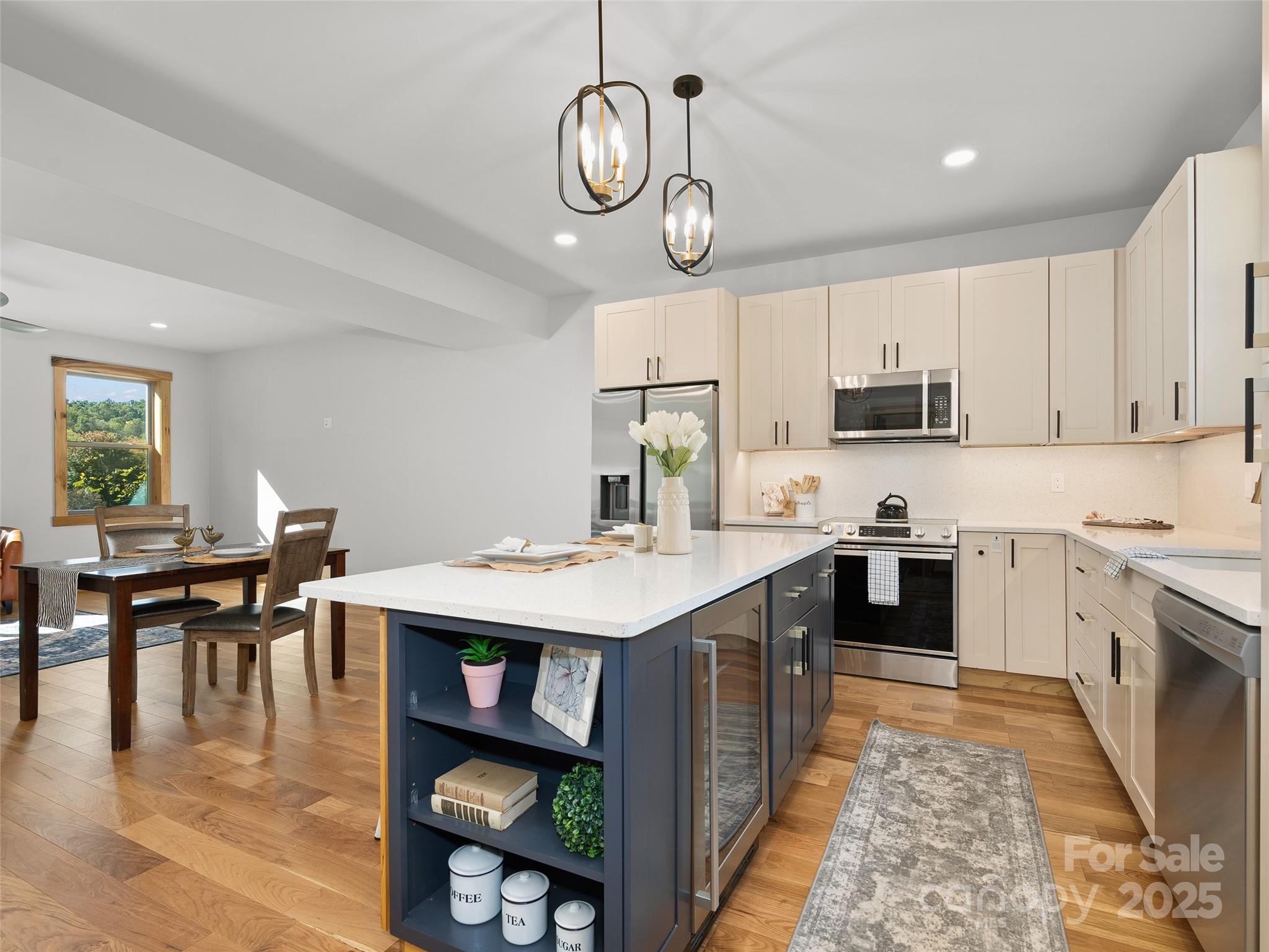 292 County Road Waynesville, NC 28785 - Photo 11 of 26 a kitchen with kitchen island granite countertop a stove a sink a dining table and chairs with wooden floor