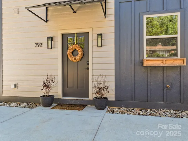 a view of a door and chair in front of house