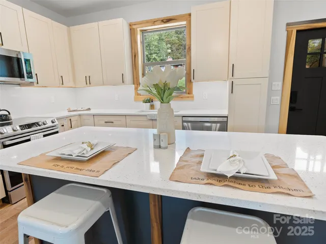 a white kitchen with a stove and a wooden floor
