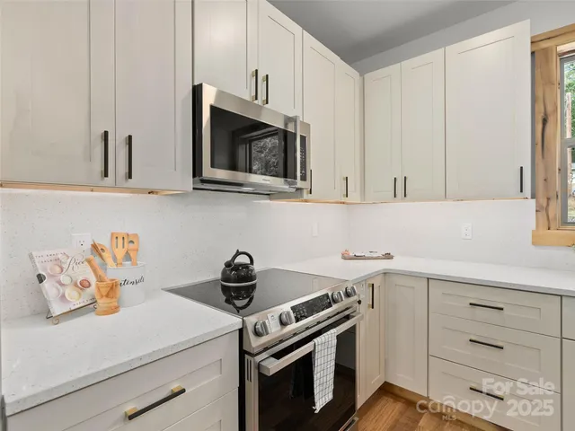 a kitchen with white cabinets and appliances