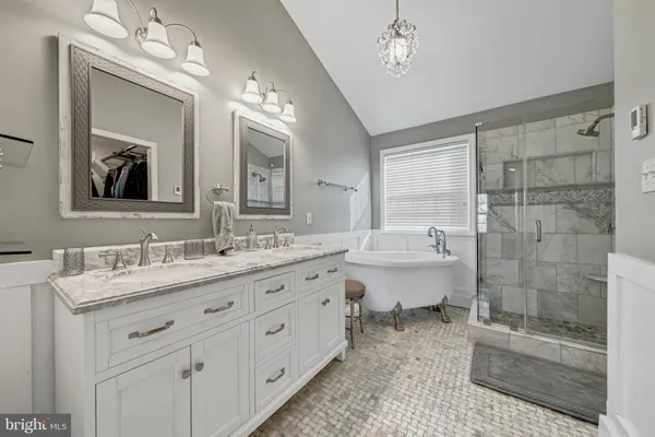 a bathroom with a double vanity sink mirror and bathtub
