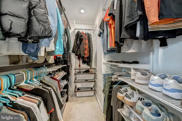 a view of walk in closet with clothes and shoes