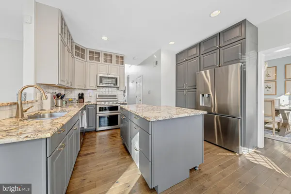 a kitchen with kitchen island a sink stove and refrigerator