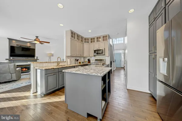a kitchen with stainless steel appliances a stove refrigerator and a sink