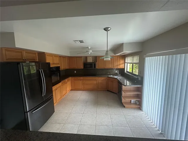 a open kitchen with stainless steel appliances granite countertop a refrigerator and a sink