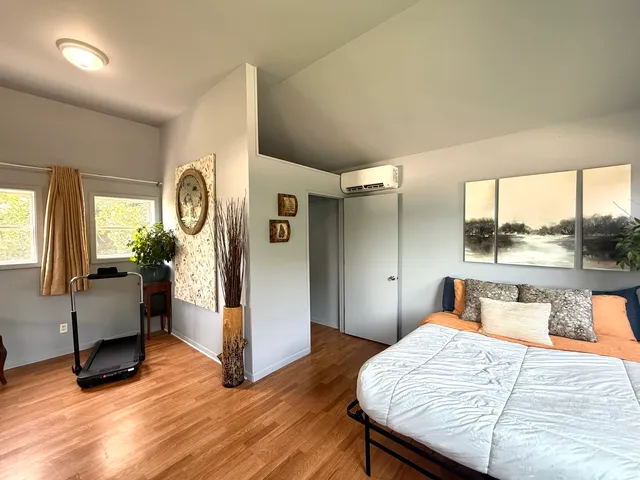 a bedroom with a bed and wooden floor