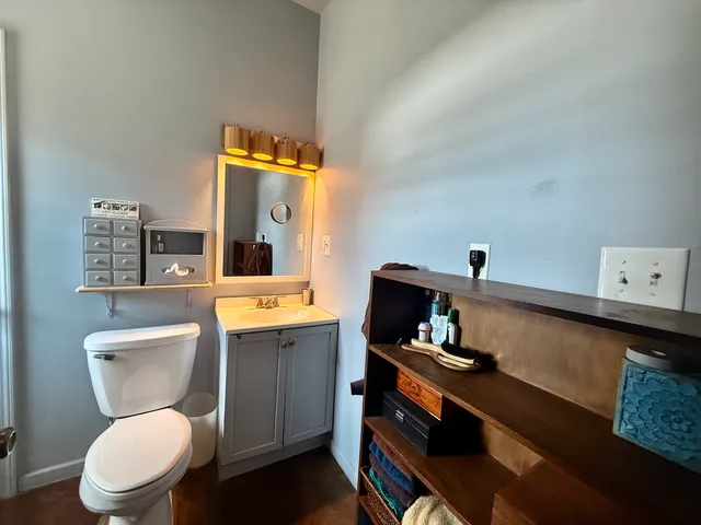 a bathroom with a toilet a sink and a mirror