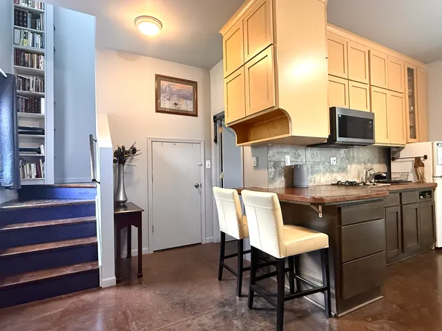 a kitchen with stainless steel appliances granite countertop a stove top oven a sink a refrigerator and a microwave