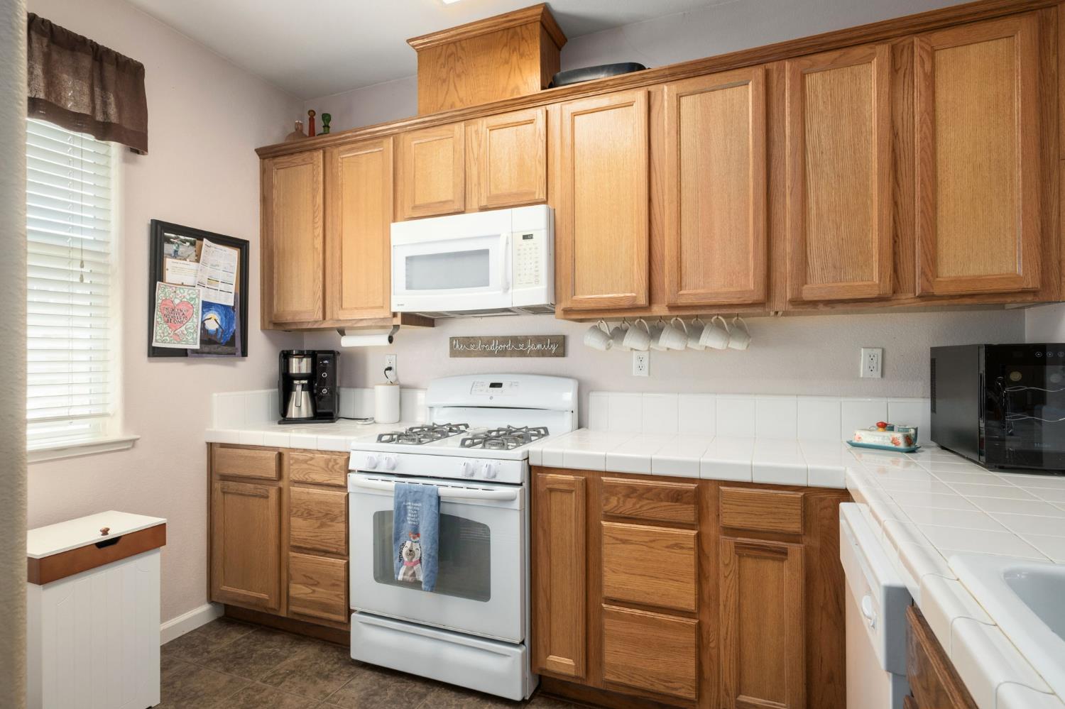 454 Sierra Avenue Reedley, CA 93654 - Photo 13 of 25 a kitchen with a stove a sink and a microwave