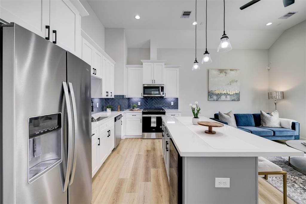 846 Elkhart Street, Unit E Houston, TX 77091 - Photo 6 of 24 a kitchen with refrigerator cabinets and wooden floor