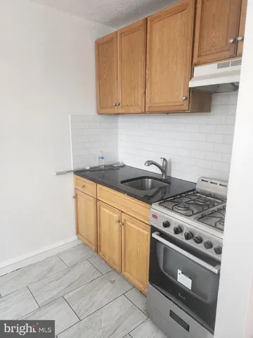 a kitchen with granite countertop a stove and a sink