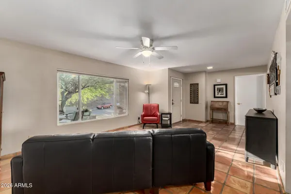 a kitchen with stainless steel appliances kitchen island granite countertop a dining table chairs and a refrigerator
