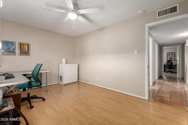 a view of a hallway with wooden floor and a livingroom