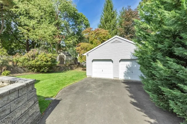 a view of a small house with a yard and large tree