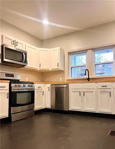 a kitchen with stainless steel appliances granite countertop a stove and a microwave