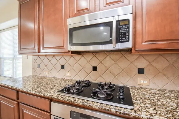 a kitchen with granite countertop white cabinets and black appliances