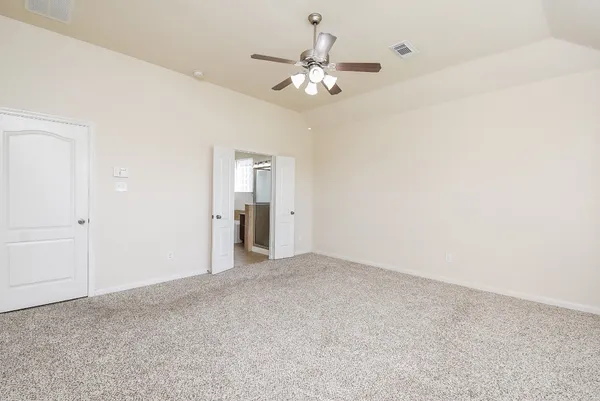 a view of an empty room with chandelier fan