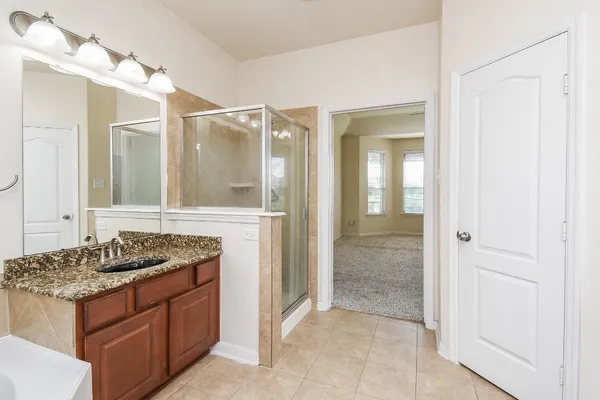 a bathroom with a granite countertop sink and a mirror