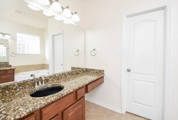 a bathroom with a granite countertop sink and a mirror