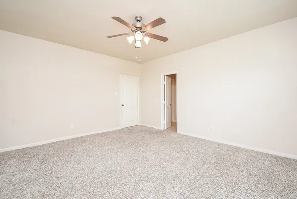 an empty room with closet and a ceiling fan