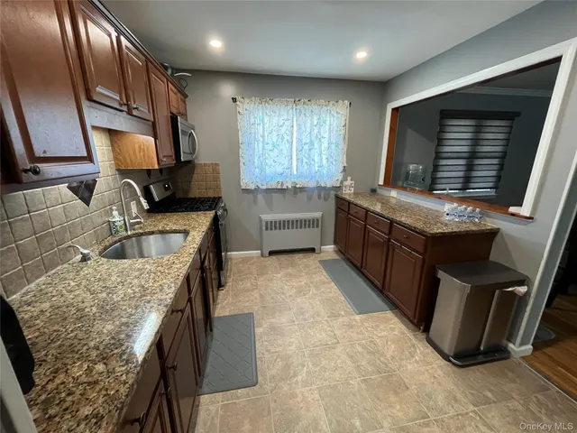 a kitchen with kitchen island granite countertop a sink stove and refrigerator