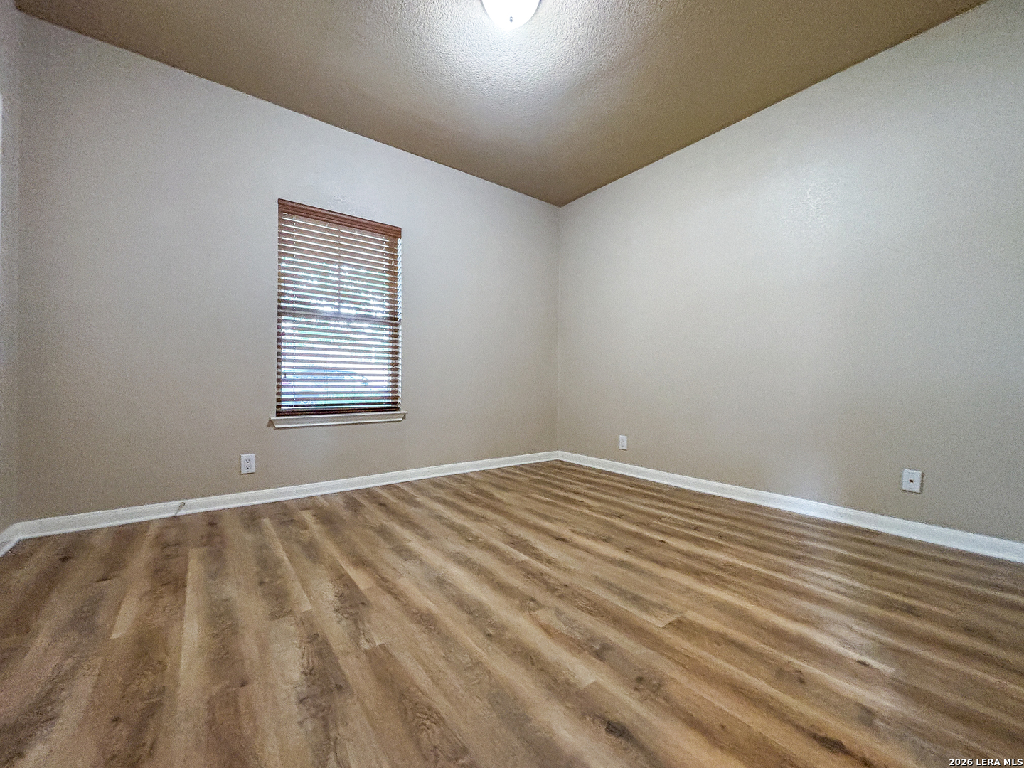 1908 Tanger Terrace New Braunfels, TX 78130 - Photo 11 of 22 a view of an empty room with wooden floor and a window