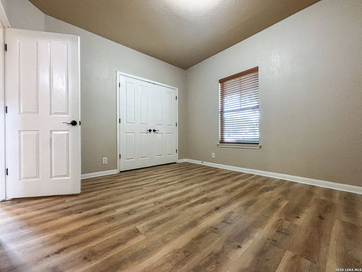 1908 Tanger Terrace New Braunfels, TX 78130 - Photo 12 of 22 an empty room with wooden floor and windows