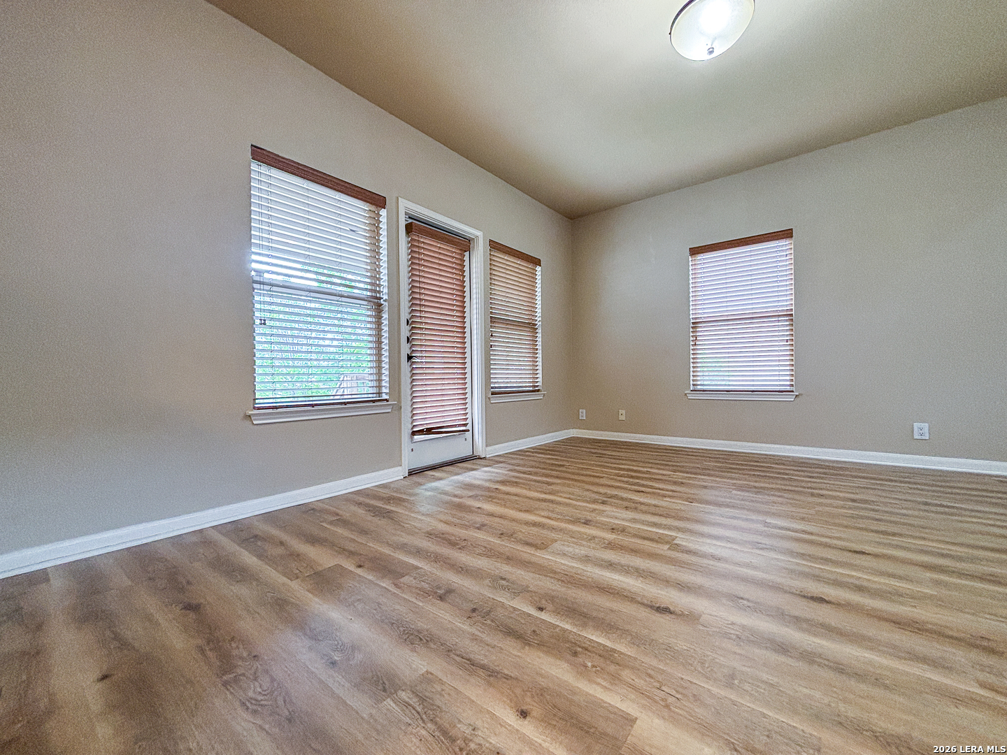 1908 Tanger Terrace New Braunfels, TX 78130 - Photo 7 of 22 an empty room with wooden floor and windows