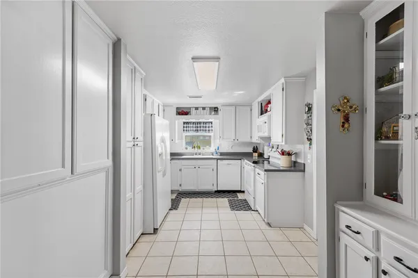 a kitchen with a refrigerator and white cabinets