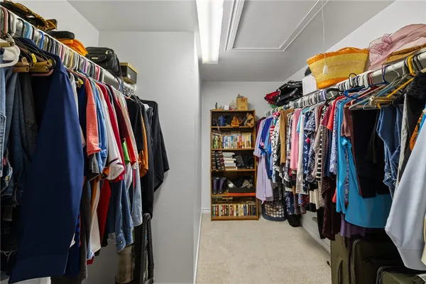 a view of walk in closet with clothes