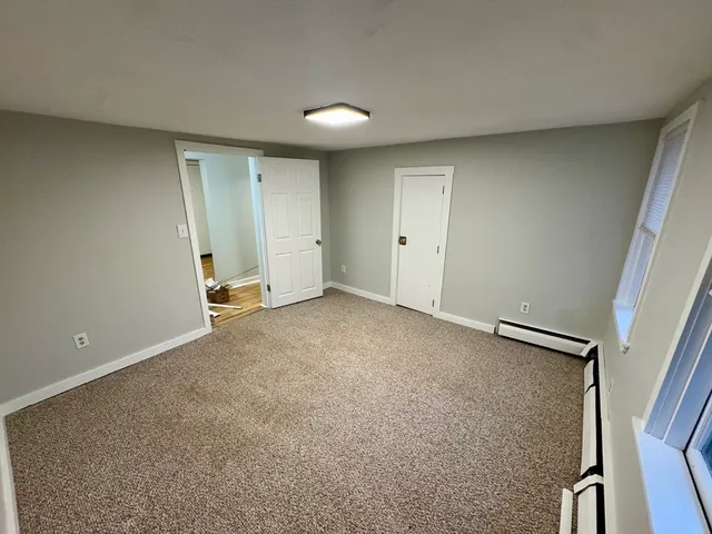 a view of room with walk in closet and wooden floor