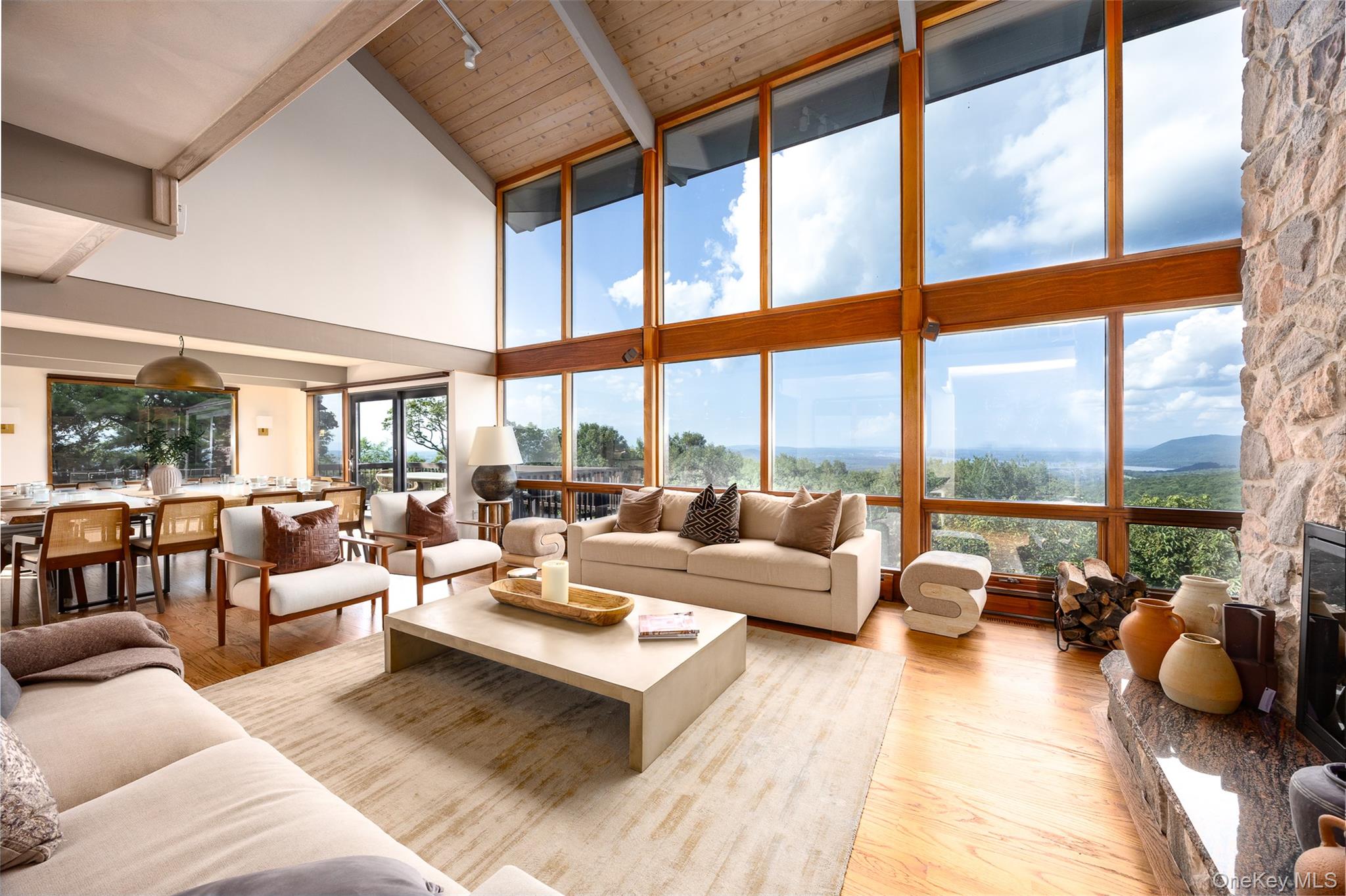 12 Mountain Brook Road Cornwall, NY 12518 - Photo 14 of 50 Living area with light wood-style floors, high vaulted ceiling, a stone fireplace, beam ceiling, and expansive windows